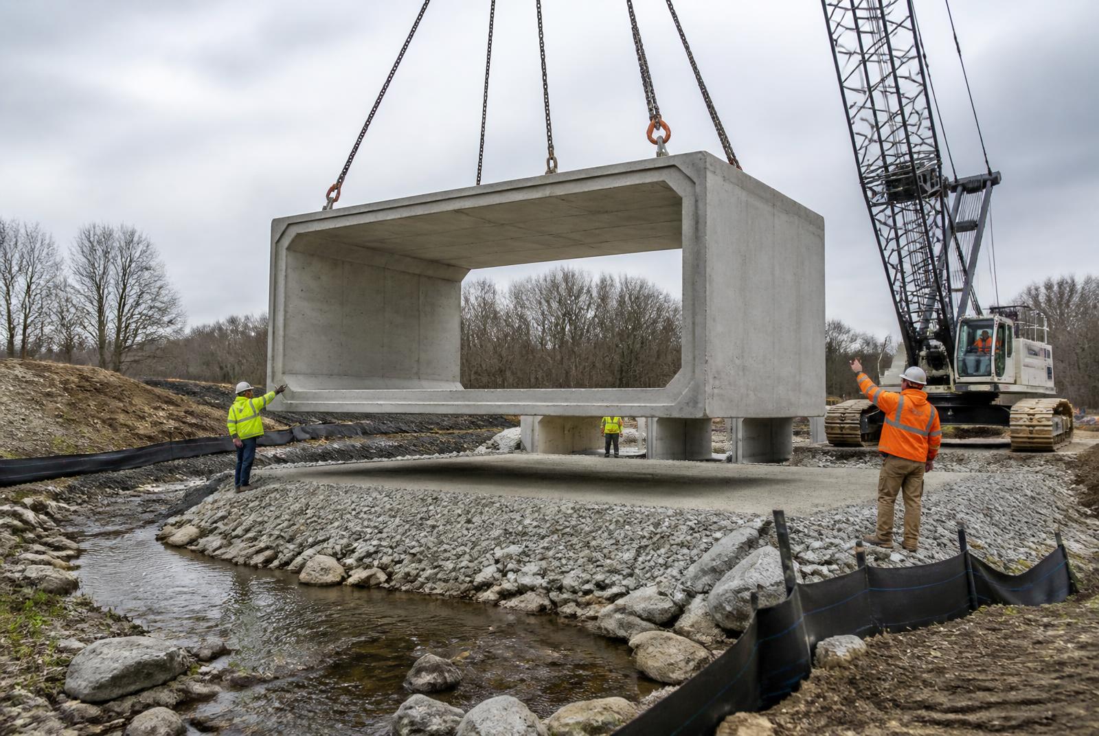 Crane setting a precast concrete culvert structure on an Ontario civil works site